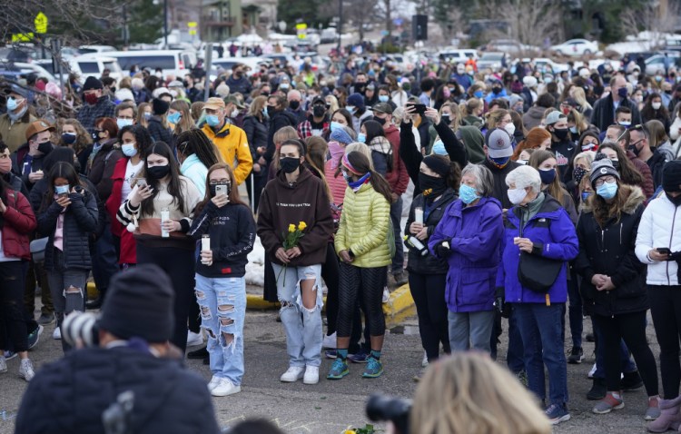 Mourners gather at a vigil for the 10 victims of the Monday massacre at a King Soopers grocery store late Thursday, March 25, at Fairview High School in Boulder, Colo. 