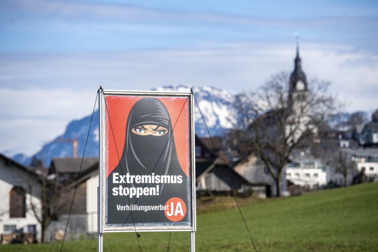 A poster supporting the initiative 'Yes to a ban on covering the face' is displayed at the Swiss village Buochs. One Sunday, voters approved a long-laid proposal to ban face-coverings like niqabs and burqas worn by some Muslim women or by protesters in ski masks or bandanas. 