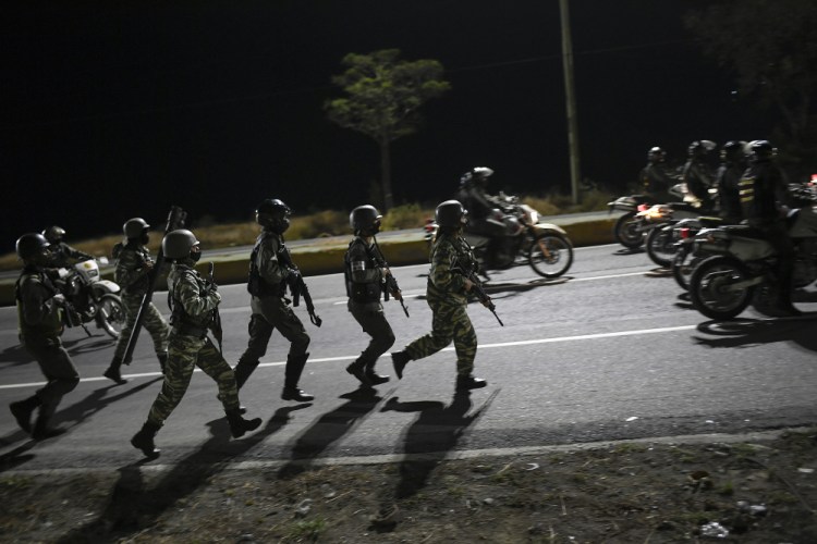 Security forces take part in a military drill to mark the eighth anniversary of President Hugo Chavez's death in Caracas, Venezuela, on Friday. The country's economy has been struggling the past few years and an estimated 5 million people have fled, mostly to neighboring countries such as Colombia, but many have settled in South Florida.