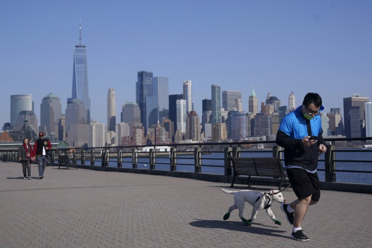 People enjoy the warming weather and a view of lower Manhattan at Liberty State Park on March 9 in Jersey City, N.J.