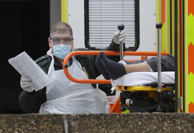 Apatient is helped from an ambulance as they arrive at St Thomas' Hospital, one of may hospitals that are in the front line of the coronavirus outbreak, in London, on March 31, 2020. 