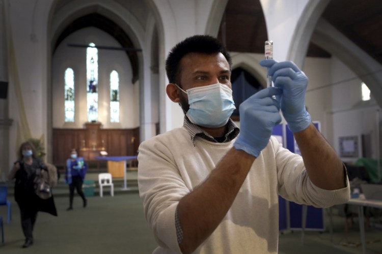 Pharmacist Rajan Shah prepares a syringe of the AstraZeneca vaccine at St John's Church, in Ealing, London, on Tuesday. In recent days, countries including Denmark, Ireland and Thailand have temporarily suspended their use of AstraZeneca's coronavirus vaccine after reports that some people who got a dose developed blood clots, even though there's no evidence that the shot was responsible. The European Medicines Agency and the World Health Organization say the data available do not suggest the vaccine caused the clots.​ 