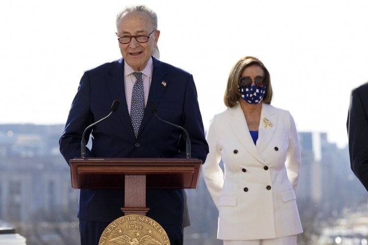 Senate Majority Leader Chuck Schumer of New York speaks as House Speaker Nancy Pelosi of California, holds a ceremony for the $1.9 trillion COVID-19 relief bill on Capitol Hill on Wednesday in Washington. 