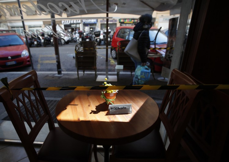 Plastic tape prevents people from sitting at a cafe table in downtown Rome on Monday. Half of Italy's regions have gone into the strictest form of lockdown in a bid to curb the latest spike in coronavirus infections that have brought COVID-19 hospital admissions beyond a manageable thresholds.