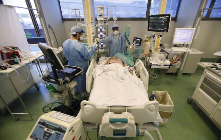Medical staff members tend to a patient in the COVID-19 Intensive Care Unit of the Papa Giovanni XIII hospital in Bergamo, Italy, on Thursday.

