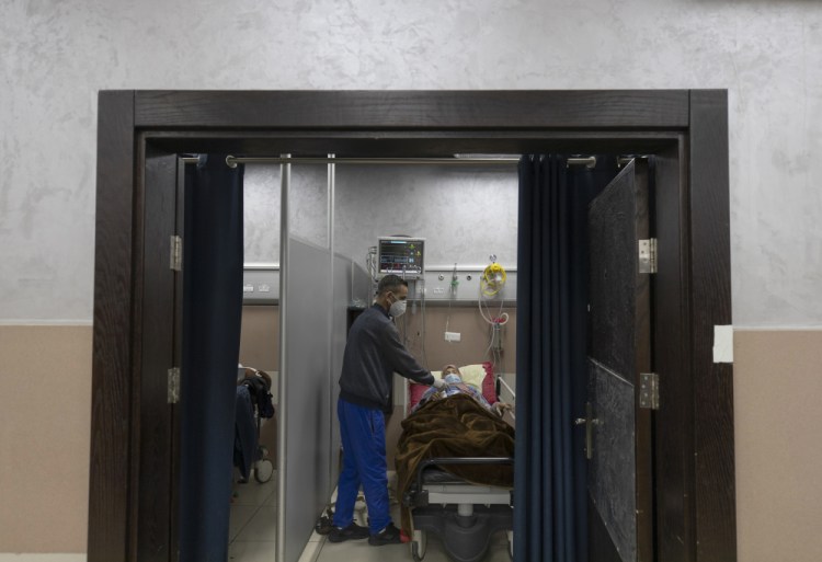 A medical staffer attends to a Palestinian patient infected with COVID-19 at the Palestine Medical Complex in the West Bank city of Ramallah on Tuesday. The Palestinian Authority has reported more than 130,000 cases in the West Bank since the outbreak began.