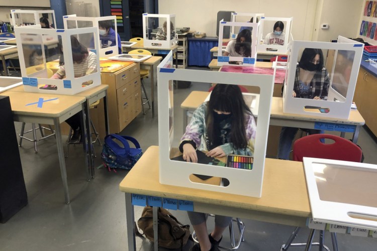 Socially distanced, and with protective partitions, students work on an art project during class at the Sinaloa Middle School in Novato, Calif. on March 2. 
