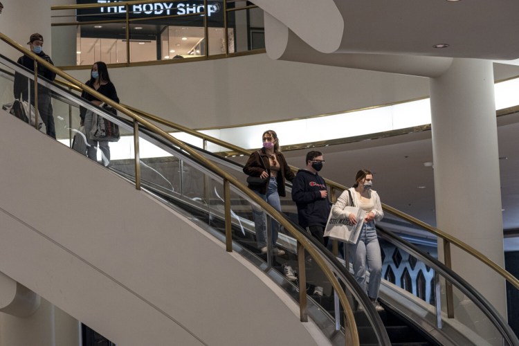Shoppers wearing protective masks ride an escalator inside the Westfield San Francisco Centre shopping mall in San Francisco on March 9. MUST CREDIT: Bloomberg photo by David Paul Morris