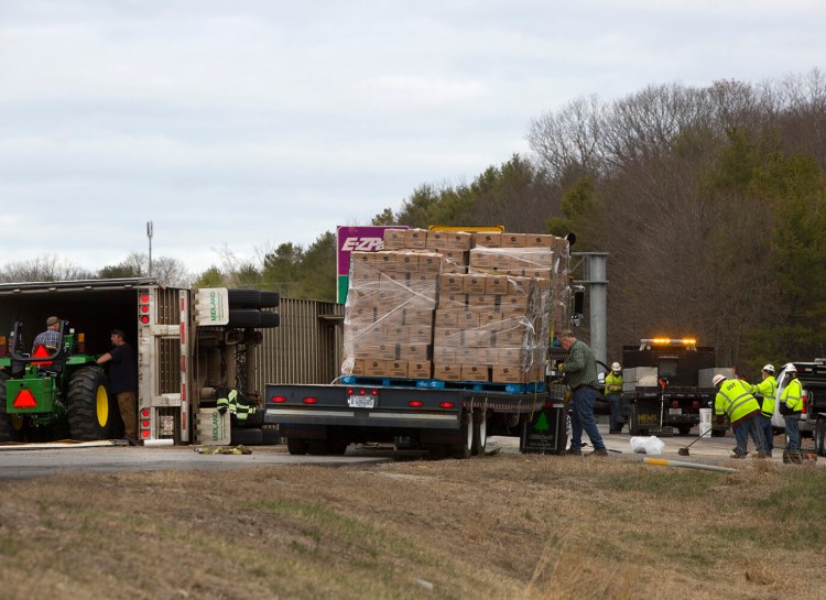 Frozen hash browns are offloaded from overturned tractor trailer at Exit 11 ramp in Falmouth on Thursday morning. 
