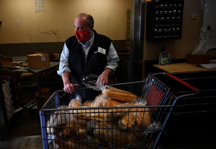 PORTLAND, ME - APRIL 20: Jeff Gouzie assistant store manager at Hannaford Supermarkets in Buxton moves a shopping cart with bread to be donated from the Hannaford on Forest Ave in Portland Tuesday, April 20, 2021. (Staff Photo by Shawn Patrick Ouellette/Staff Photographer)