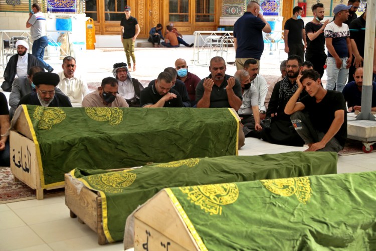 Mourners pray near the coffins of coronavirus patients who were killed in a hospital fire, during their funeral Sunday at the Imam Ali shrine in Najaf, Iraq. Iraq’s Interior Ministry said Sunday that more than 80 people died and more than 100 were injured in a catastrophic fire that broke out in the intensive care unit of a Baghdad hospital tending to severe coronavirus patients in the early morning Sunday.