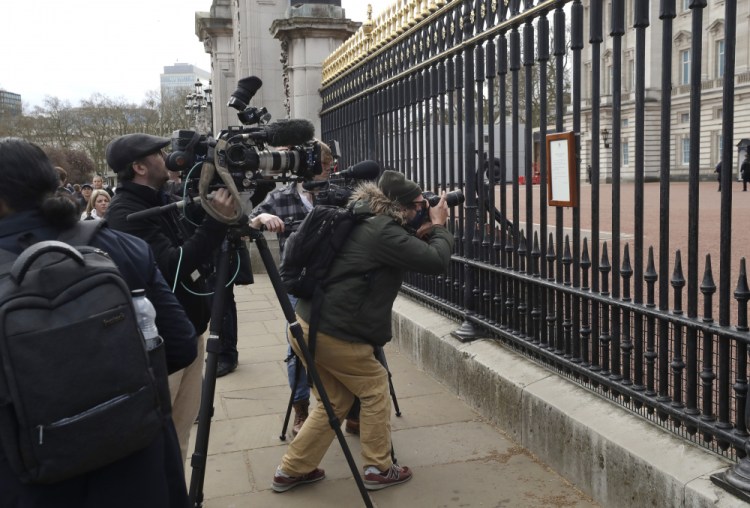 Members of the media take images of an announcement about the death of Britain's Prince Philip displayed on the fence of Buckingham Palace on Friday in London. 
