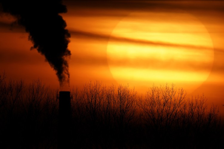 Emissions from a coal-fired power plant are silhouetted against the setting sun Feb. 1 in Independence, Mo. 
