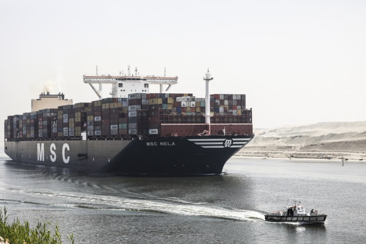 A container ship passes through Suez Canal, Egypt, Tuesday, April 6. The Suez Canal chief said that authorities are negotiating a financial settlement with the owners of a massive vessel that blocked the crucial waterway for nearly a week. 