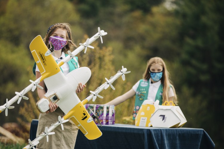 Girl Scouts Alice, right, and Gracie pose April 14 with a Wing delivery drone in Christiansburg, Va. 

