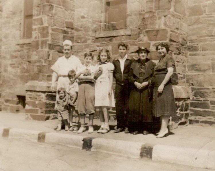 The Panagakos family stand in front of Saint Stephen’s Church at 667 Congress Street (now luxury hi-rise Hiawatha House) in Longfellow Square.