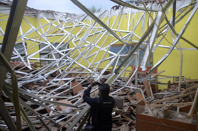 A local journalist films the damage to a classroom at a school after an earthquake in Malang, East Java, Indonesia, on Saturday

