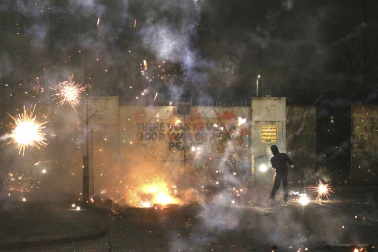 A firework explodes Wednesday as Nationalist and Loyalist rioters clash on Lanark Way in West Belfast, Northern Ireland. 

