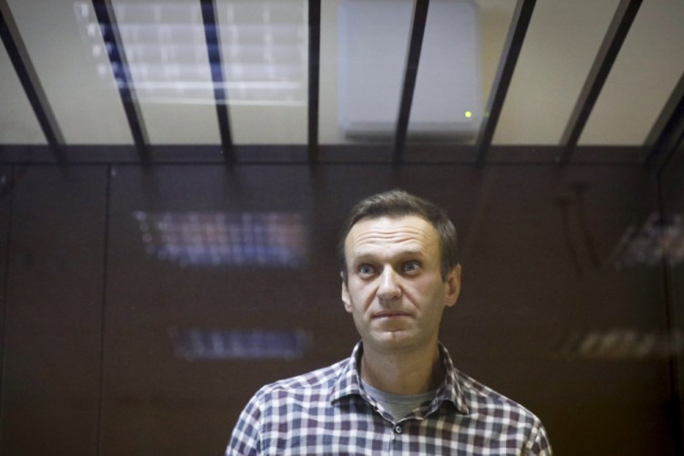 Russian opposition leader Alexei Navalny stands in a cage in the Babuskinsky District Court in Moscow, Russia on Feb. 20, 2021.  Navalny, who is in the third week of a hunger strike, will be admitted to a hospital in another prison, the Russian state penitentiary service said Monday.