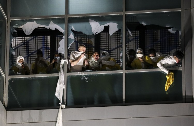 Inmates, from a second cell block, try to breath through broken windows after officers deployed a chemical irritant at the St. Louis Justice Center, known as the city jail, on Sunday. 