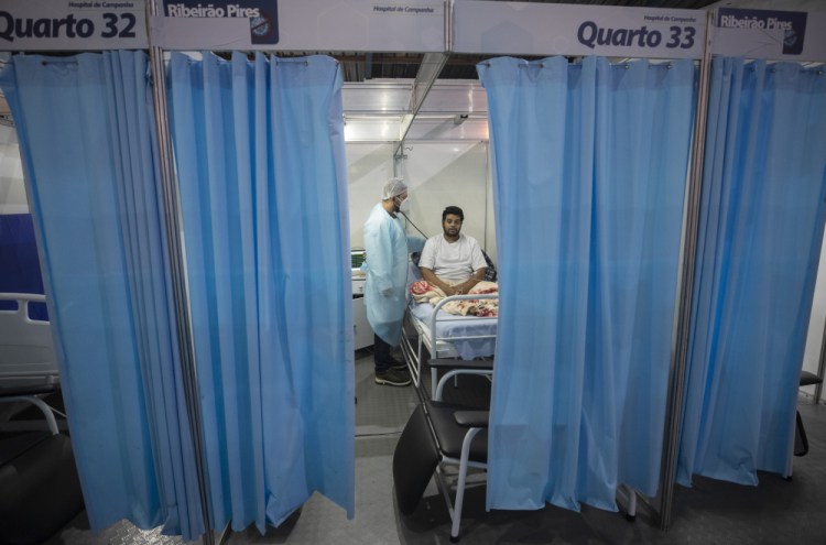 Doctor Malek Imad treats 34-year-old COVID-19 patient Everton Barbosa Godoy at the emergency unit of a field hospital Tuesday in Ribeirao Pires, greater Sao Paulo area, Brazil.