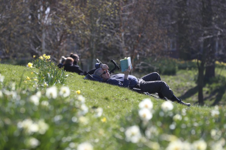 People enjoy the sunny weather in Sefton Park in Liverpool, England, on Sunday. U.K. Prime Minister Boris Johnson is expected to provide more details about vaccine passports this week. 