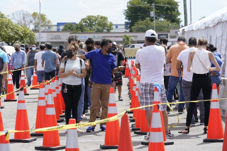 People wait in line to receive a COVID-19 vaccine at a FEMA vaccination center at Miami Dade College last month in Miami. 