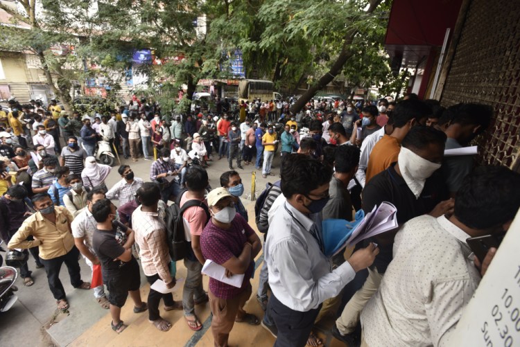 People wait in queues outside the office of the Chemists Association to demand necessary supply of the anti-viral drug Remdesivir, in Pune, India on April 8. As India faces a devastating surge of new coronavirus infections overwhelming the health care system, people are turning to desperate measures to keep loved ones alive. 
