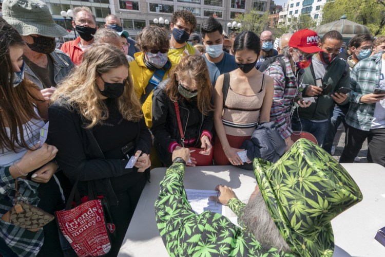 A man wearing a cannabis costume hands out marijuana cigarettes in New York during a "Joints for Jabs" event April 20, where adults who showed their COVID-19 vaccination cards received a free joint.