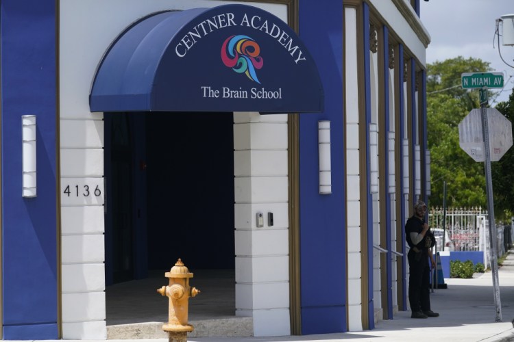 A security guard walks the perimeter of the Centner Academy this month in Miami. The private school founded by an anti-vaccination activist in South Florida has warned teachers and staff against taking the COVID-19 vaccine. 