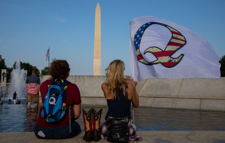 QAnon supporters wait for a military flyover at the World War II Memorial during Fourth of July celebrations last year in Washington, D.C.. MUST CREDIT: Photo for The Washington Post by Evelyn Hockstein
