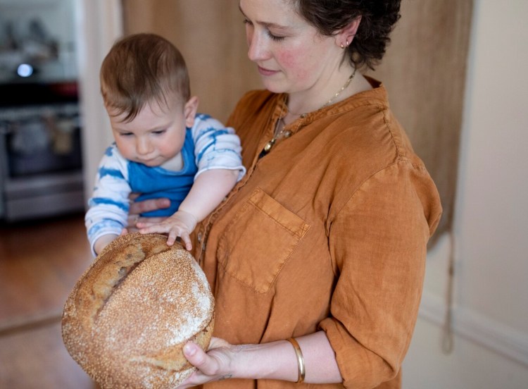 SOUTH PORTLAND, ME - MAY 5: Sandy Winthrop touches a loaf of his mom Kate WhittemoreÕs tahini wheat sourdough on Wednesday, May 5, 2021. Whittemore, who worked at Palace Diner and Rose Foods, is an avid at home baker. ÒHe already loves touching the dough,Ó Whittemore said about her 10-month-old son. (Staff photo by Brianna Soukup/Staff Photographer)
