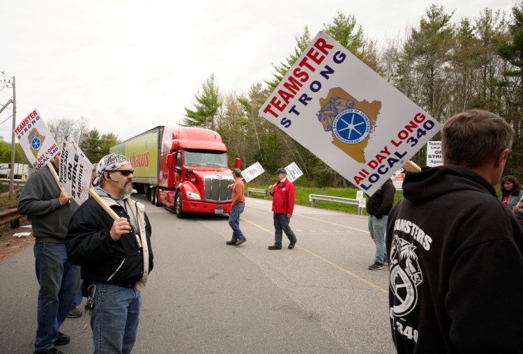WELLS, ME - MAY 3: Randy Willis, left, and other drivers with Shaw's supermarkets walk a picket line as a truck leaves the Shaw's distribution facility in Wells on Monday, May 3, 2021. Shaw's drivers and mechanics, members of Teamsters Local Union No. 340, are striking because contract negotiations have stalled since the company has not presented a counter proposal for two months. (Staff photo by Gregory Rec/Staff Photographer)