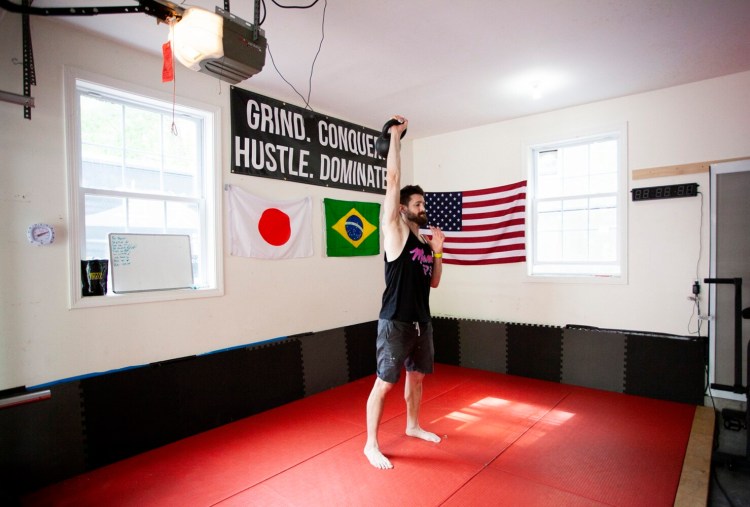 PORTLAND, ME - MAY 23: Austin Miller, chef and owner of Mami, works out with a kettlebell in his home gym in Portland on Sunday, May 23, 2021. Miller built a home gym in his garage during the pandemic and says he is in the best shape of his life now. (Staff Photo by Ariana van den Akker/Staff Photographer)
