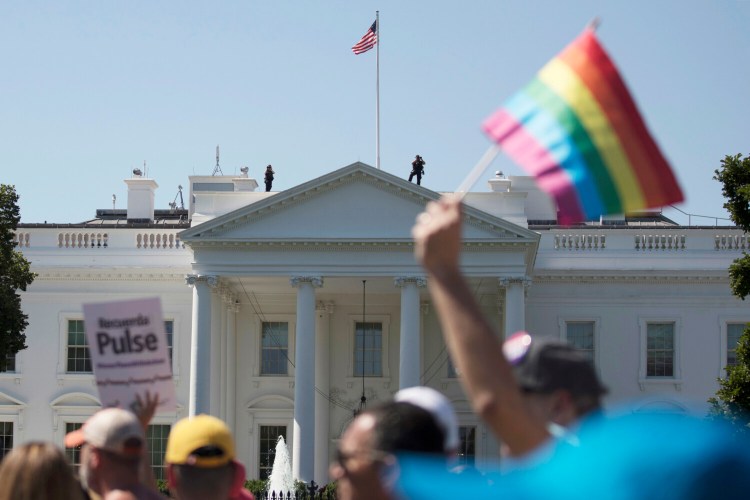 Equality March for Unity and Pride participants march past the White House on June 11, 2017. 
The Biden administration says the government will protect gay and transgender people against sex discrimination in health care, reversing a Trump-era policy.