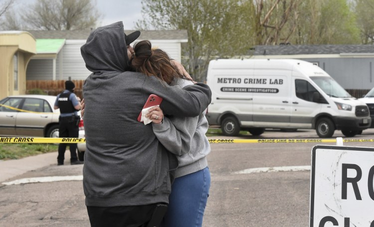 Freddy Marquez kisses the head of his wife, Nubia Marquez, near the scene where her mother and other family members were killed in a mass shooting early Sunday in Colorado Springs, Colo. 