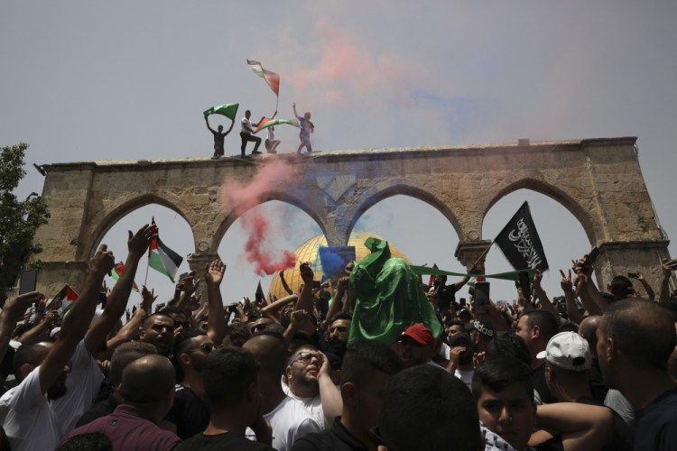 Palestinians wave national flags in front of the Dome of the Rock in the al-Aqsa mosque complex in Jerusalem on Friday as a cease-fire took effect between Hamas and Israel after an 11-day war.