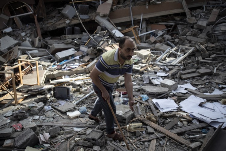 A Palestinian man inspects the damage of a house destroyed by an early morning Israeli airstrike, in Gaza City, Tuesday, May 18. Israel carried out a wave of airstrikes on what it said were militant targets in Gaza, leveling a six-story building in downtown Gaza City, and Palestinian militants fired dozens of rockets into Israel early Tuesday, the latest in the fourth war between the two sides, now in its second week.