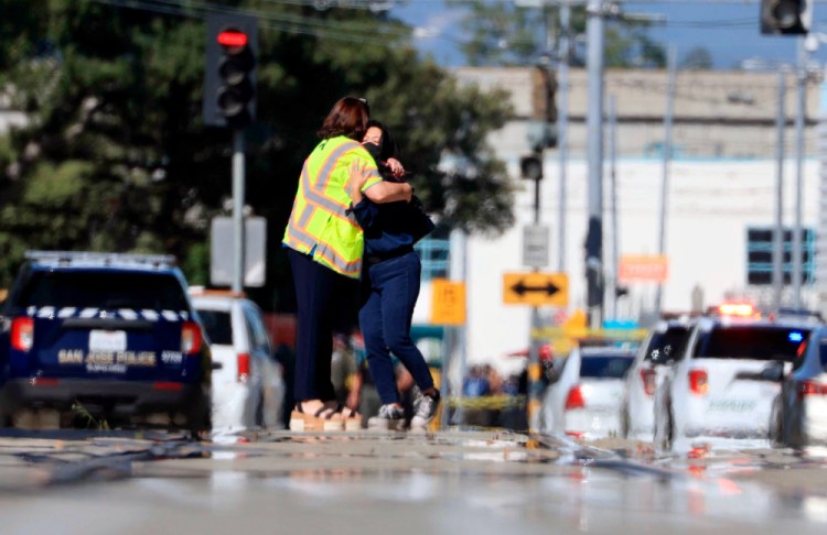 Two people hug on Younger Avenue outside the scene of a shooting in San Jose, Calif., on Wednesday, May, 26. 