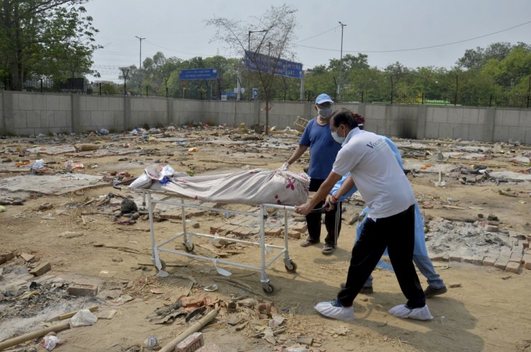 Body of a COVID-19 victim is wheeled in at a converted crematorium Saturday in New Delhi.