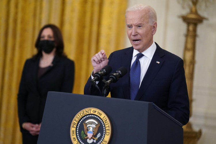 Vice President Kamala Harris listens as President Biden speaks about the economy on Monday in the East Room. “We’re moving in the right direction,” Biden said. "I never said ... that climbing out of the deep, deep hole our economy was in would be simple, easy, immediate or perfectly steady.