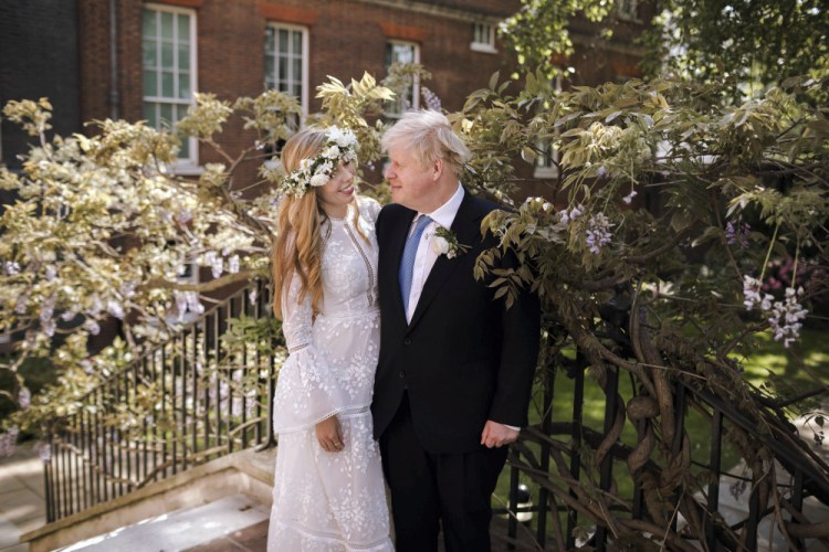 Britain's Prime Minister Boris Johnson and Carrie Johnson pose together for a photo in the garden of 10 Downing Street after their wedding on Saturday. 

