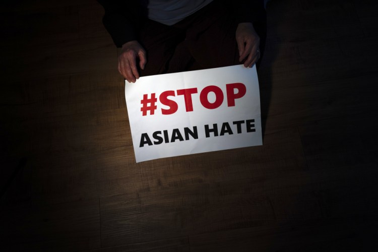 Jen Ho Lee, a 76-year-old South Korean immigrant, poses in her apartment in Los Angeles with a sign from a recent rally against anti-Asian hate crimes she attended on March 31. 