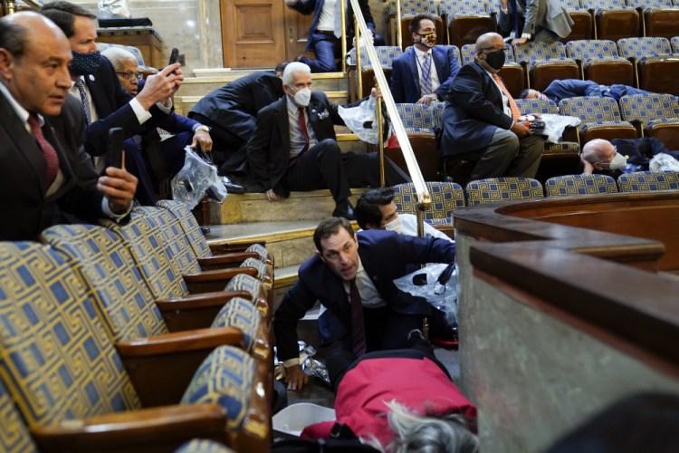People shelter in the House chamber as rioters try to break in at the U.S. Capitol in Washington during the Jan. 6 insurrection. 