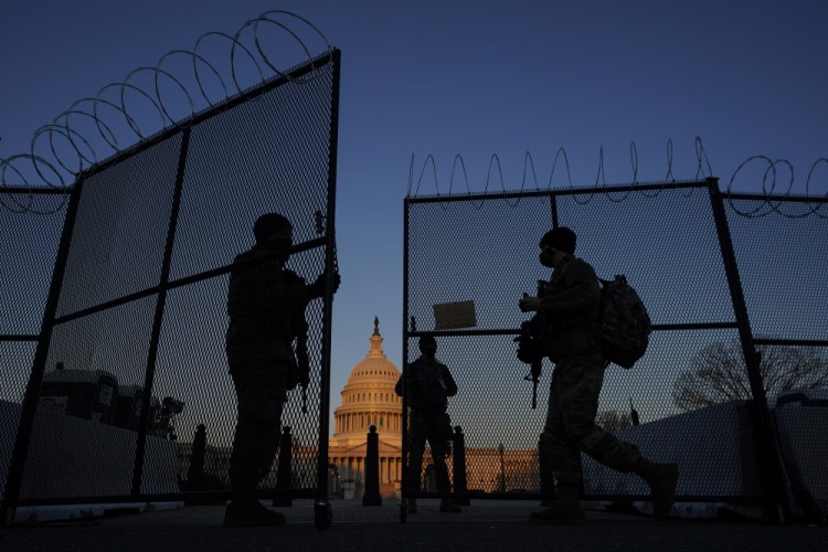 Members of the National Guard open a gate in the razor wire topped perimeter fence around the Capitol at sunrise in Washington in March. Threats to members of Congress have more than doubled this year, according to the U.S. Capitol Police, and many members say they fear for their personal safety more than they did before the siege. 
