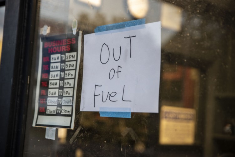 A sign reading "Out of Fuel" is taped to the window at an Exxon gas station in Lynchburg, Va., on Tuesday. More than 1,000 gas stations in the Southeast reported running out of fuel, primarily because of what analysts say is unwarranted panic-buying among drivers, following the shutdown of a major pipeline by hackers.