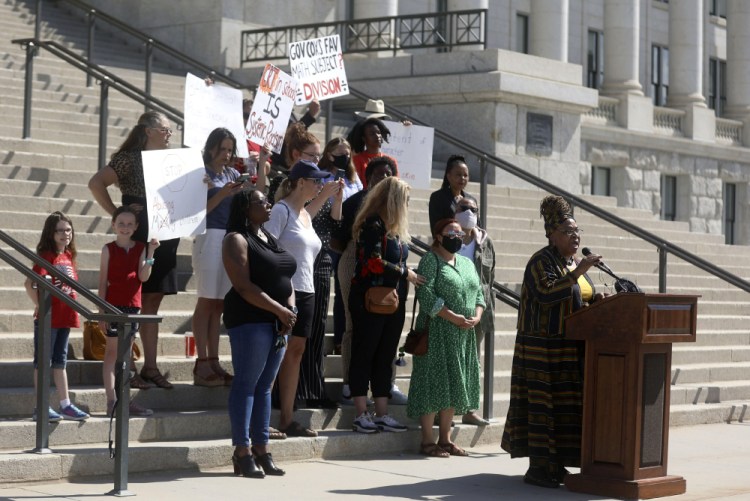 Betty Sawyer joins educators and community activists in protesting Utah lawmakers' plans to pass resolutions encouraging a ban of critical race theory concepts outside of the Capitol in Salt Lake City on May 19 as supporters and counterprotesters stand behind her. 

