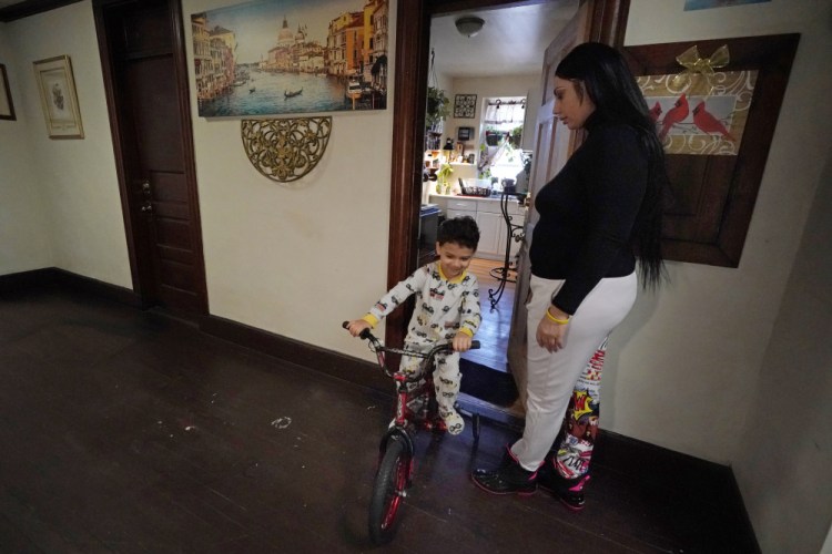 Isabel Miranda's 4-year-old son, Julian, rides his bike into the hallway of their rental apartment March 10 in Haverhill, Mass. 