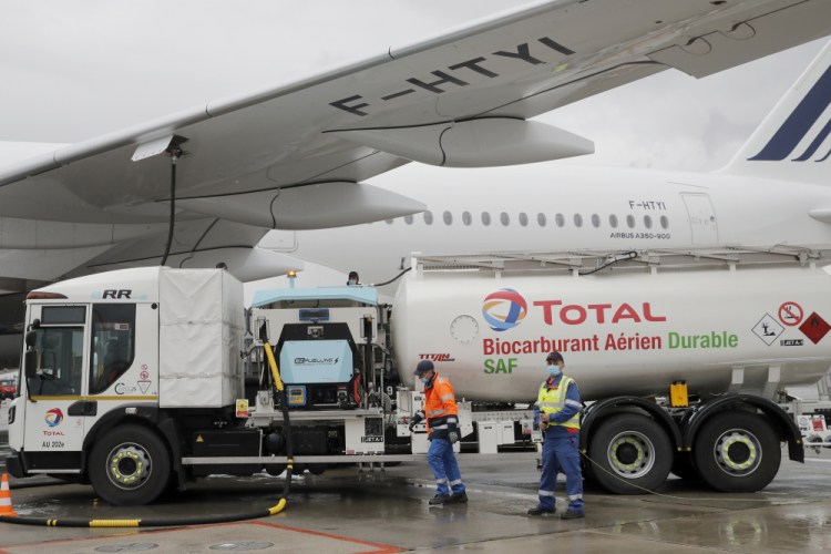 Workers refuel an Airbus A350 with sustainable aviation fuel at Charles de Gaulle airport on Tuesday. Air France-KLM is aiming to make 5 percent of its fuel sustainable by 2030. 