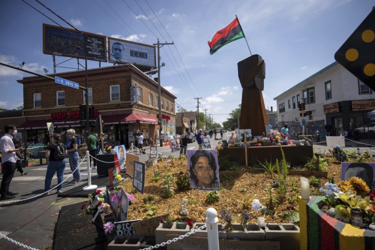 People walk through George Floyd Square on the one-year anniversary of his death on Tuesday in Minneapolis.  